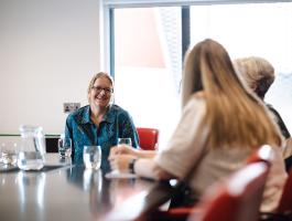 People sat around a table in a meeting